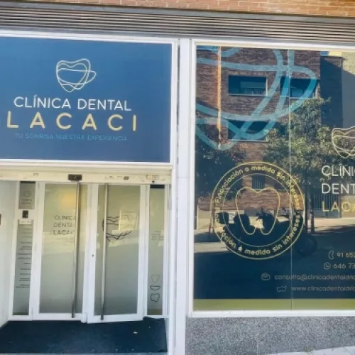 Fachada exterior de la Clínica Dental Lacaci con ventanas grandes y letreros con información de contacto.
