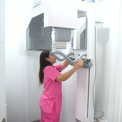 Técnica dental de perfil ajustando equipo de radiografía para el paciente